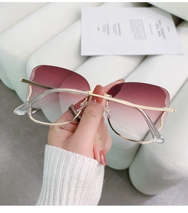 Detail shot of rimless butterfly sunglasses with gradient purple lenses and gold metal temples