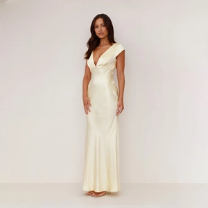 Detail of elegant pale yellow satin dress with deep V-neck and smooth fabric texture