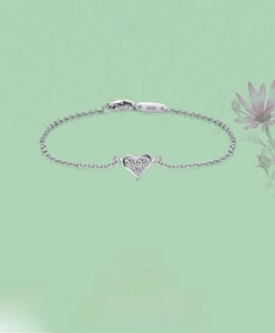 Macro detail of S925 sterling silver heart bracelet with sparkling stones and hallmark