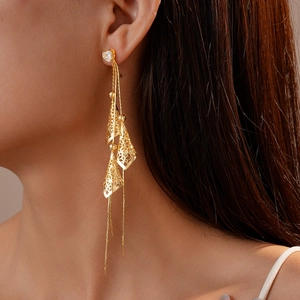 Detail of 18K gold plated heart chain earrings with geometric hollow texture on model