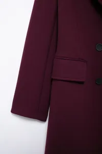 Détail macro d'un manteau en laine bordeaux foncé avec boutons et texture sergée