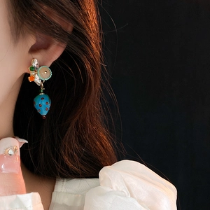 Detailed view of luxury strawberry earrings with blue crystals and gold-plated finish