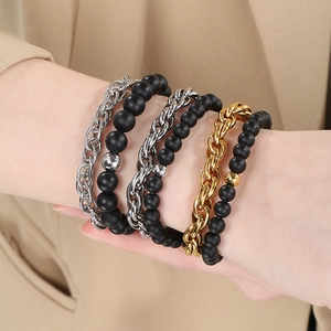 Close-up of 6-piece men's bracelet set with black matte beads and metal chains