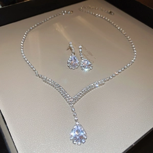 Detailed view of silver water drop V-shaped jewelry set with sparkling crystals in a gift box