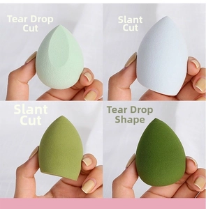 Detailed view of four multi-colored makeup sponges in teardrop and slanted cut shapes