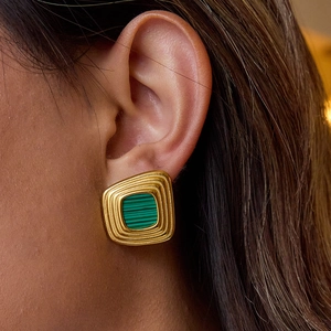 Gros plan d'élégantes boucles d'oreilles carrées en or avec incrustation de malachite verte