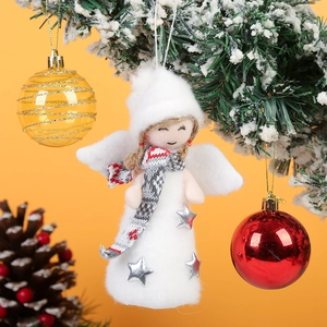 Detail of white plush angel ornament with silver star hanging on a Christmas tree