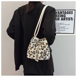 Detail of plush leopard print bucket bag with elegant pearl drawstring charms on model