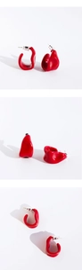 Detailed views of irregular red enamel earrings with silver posts in three angles