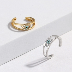 Detail of dual-band evil eye rings in gold and silver with blue stones and zircons