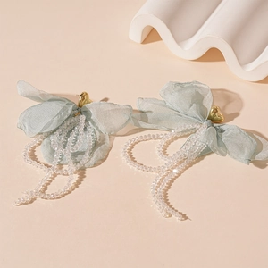 Détails de boucles d'oreilles cœur avec pétales en dentelle verte et glands cristal