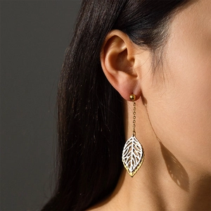 Elegant gold and silver leaf tassel earrings for women shown on a model portrait