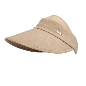 Close-up of wide brim sun hat showing khaki woven fabric and golden metal logo tag