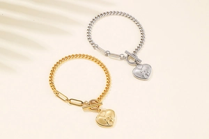 Detail of gold and silver heart bracelets with T-bar clasp and paperclip chain