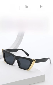 Detail of black cat eye sunglasses with bold frames and gold triangle temple accents