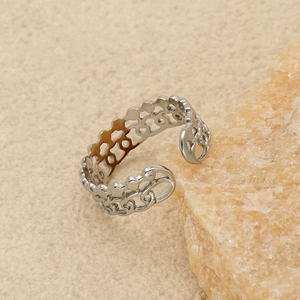 Minimalist silver stainless steel hollow wavy ring with adjustable open design on a stone base