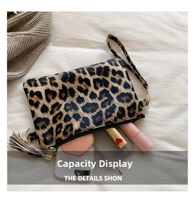 Leopard print clutch bag with zipper showing internal space for makeup and fringe detail