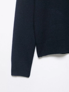 Detail of navy knit cardigan showing ribbed cuffs and fine stitching texture