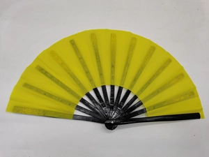 Detail view of a bright yellow folding fan with black lacquered bamboo ribs on white background