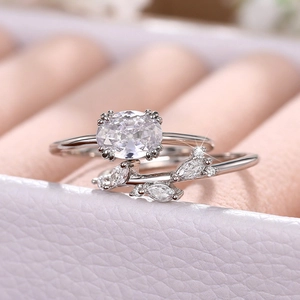 Detalle macro de conjunto de anillos de plata con diseño de hojas y circonitas marquise