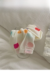 Detail of white cotton sock with colorful polka dots and cute puppy label in a glass