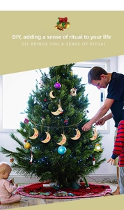 Detailansicht von DIY-Mondanhängern aus Holz mit HAPPY-Schriftzug an einem Weihnachtsbaum