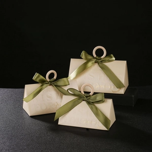 Three beige champagne wedding candy boxes with wooden handles and green ribbons