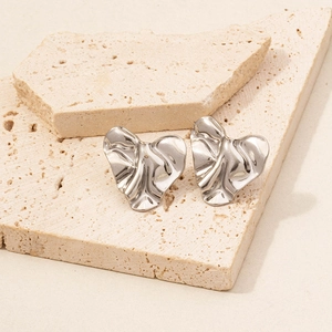 Macro shot of silver 304 stainless steel earrings with irregular crumpled heart texture