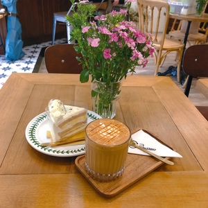 Daisy lace bag shown in a leisure afternoon tea scene with cake and coffee on wooden tray