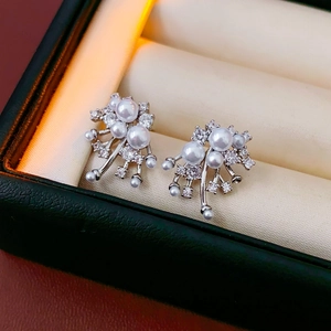 Macro shot of gold-plated fireworks pearl earrings with sparkling crystal accents