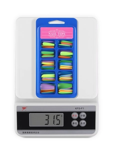 Macro shot of 100pcs colorful long ballerina nail tips set on a digital scale for weight check