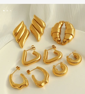 Detailed arrangement of textured gold croissant and triangular earrings on white porcelain