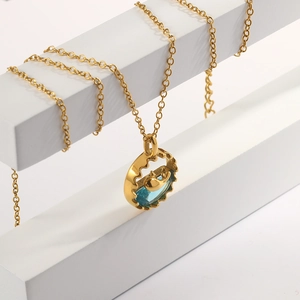 Nahaufnahme des 18K vergoldeten Wal-Anhängers mit blauem Edelstein an Metallkette