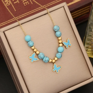 Gold chain necklace with blue turquoise beads and three butterfly pendants in a gift box