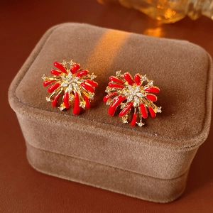Macro shot of red and gold floral earrings with crystal inlay on a velvet jewelry box