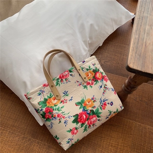 Detailed view of floral tote bag with vintage rose pattern and leather handles