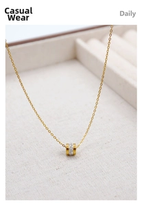 Macro shot of gold cylinder pendant with sparkling zircon on a dainty chain