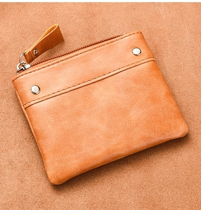 Detail view of vintage brown leather coin purse with metallic zipper and rivet accents