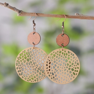 Detail of vintage geometric earrings with beige honeycomb pattern on wood branches
