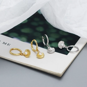 Elegant shell drop earrings with pearls in gold and silver finish on white silk