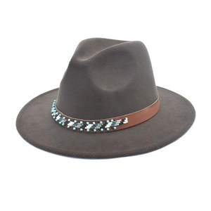 Détail du chapeau fedora marron foncé avec bande en cuir perlé et à larges bords