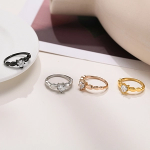Detailed view of four heart-shaped zircon rings in black, silver, rose gold, and gold