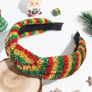 Detailed shot of Christmas headband with red green and gold glitter stripes on wood