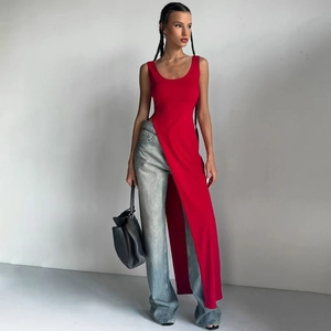 Haut long sans manches rouge à fente haute stylisé avec un jean pour un look urbain chic