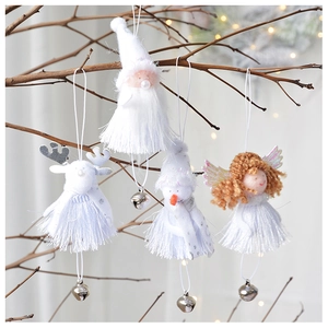 Detail of plush Christmas ornaments with bells on branches with warm bokeh lights