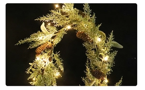 Close-up of Christmas pine garland with natural cones and warm white LED lights
