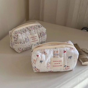 Detailed close-up of quilted cotton cosmetic bags with cute cartoon prints and zippers