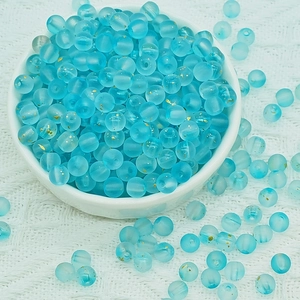 Detailed view of light blue frosted glass beads with gold foil foil for DIY jewelry