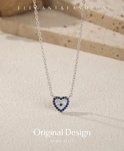 Macro shot of silver heart pendant with blue and white zircons on beige stone