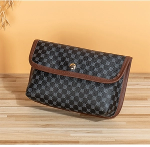 Detail of vintage geometric patterned clutch bag with brown trim and gold metallic snap button